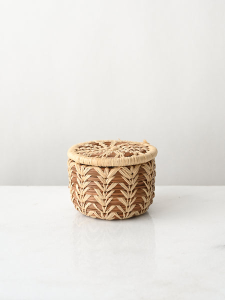 Woven basket with a lid on a white surface and background